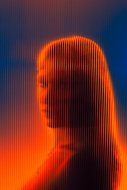 Ribbed-glass portrait lit in orange